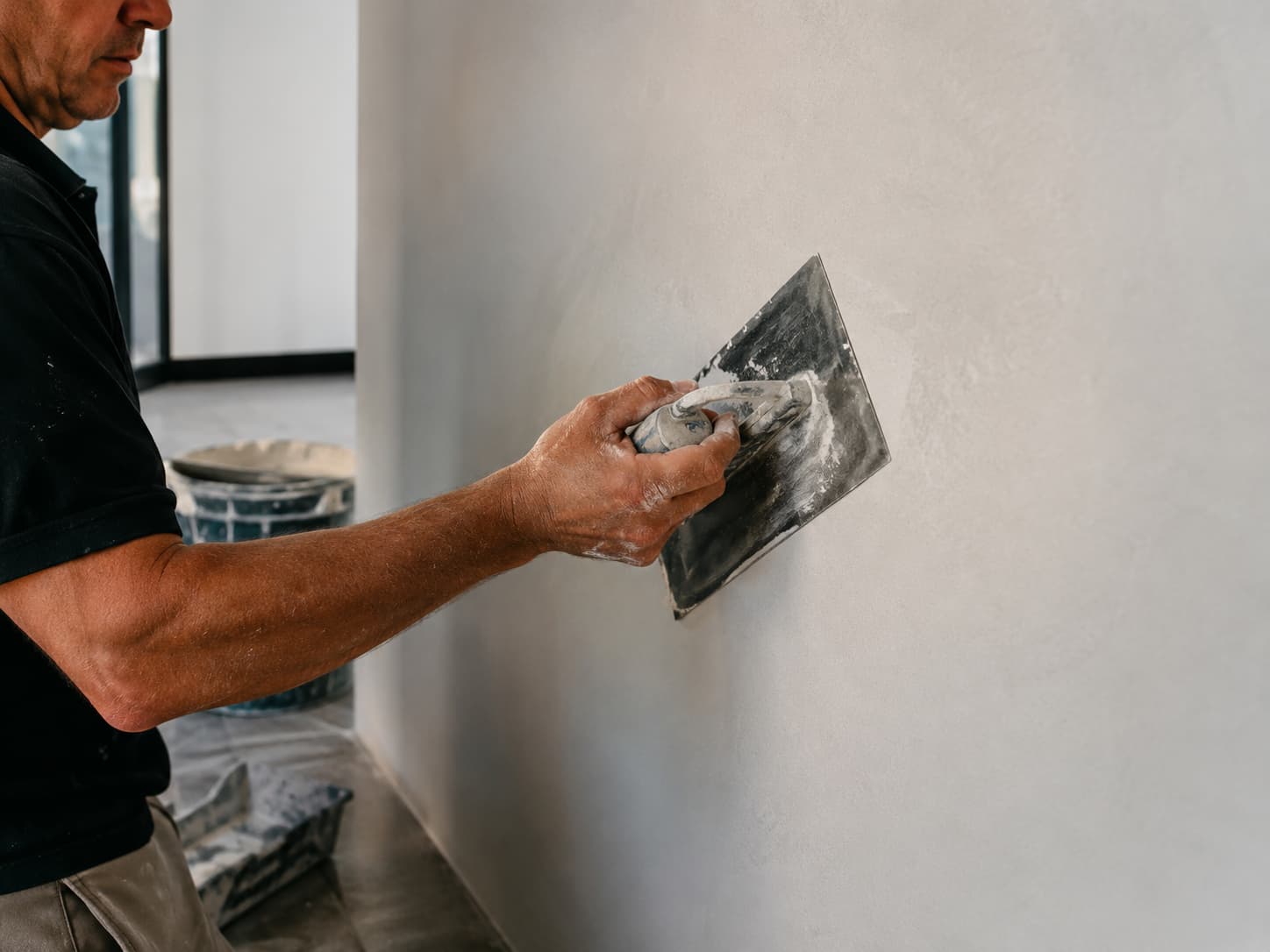 Profissional executando acabamento fino em parede interna